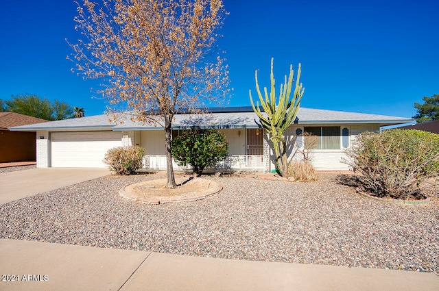 ranch-style house featuring solar panels and a garage