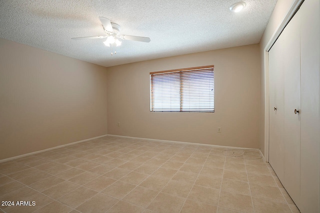 unfurnished bedroom featuring ceiling fan, a closet, and a textured ceiling