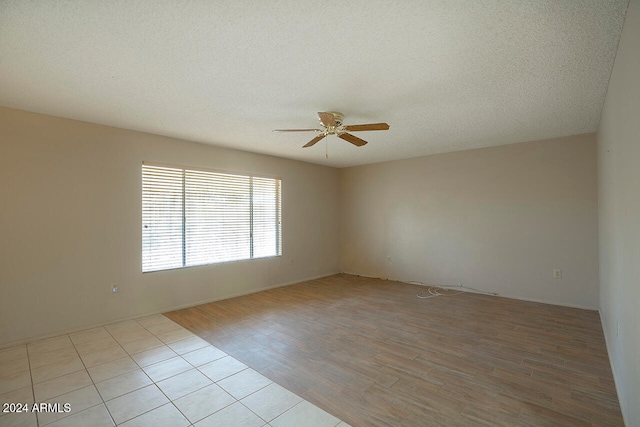 unfurnished room with ceiling fan, light hardwood / wood-style floors, and a textured ceiling