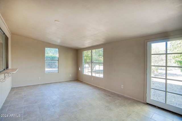 tiled empty room featuring plenty of natural light