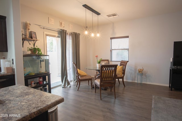 dining room featuring dark wood-type flooring, visible vents, and baseboards