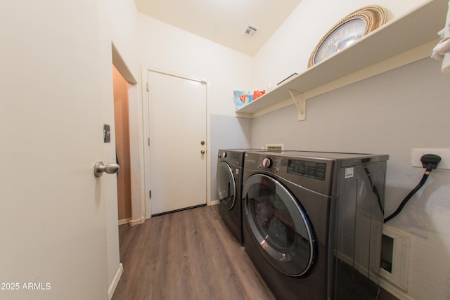 laundry room with baseboards, washing machine and dryer, visible vents, laundry area, and wood finished floors