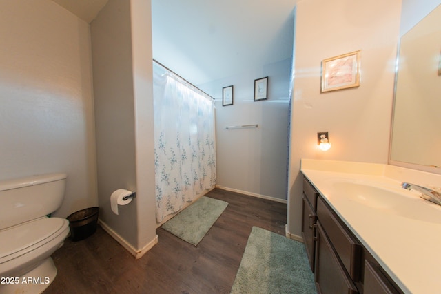 bathroom with vanity, a shower with curtain, toilet, wood finished floors, and baseboards
