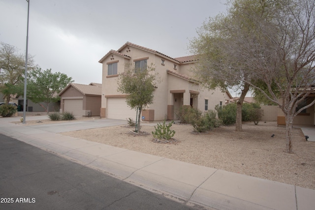view of front of house with driveway, stucco siding, a tile roof, and a garage
