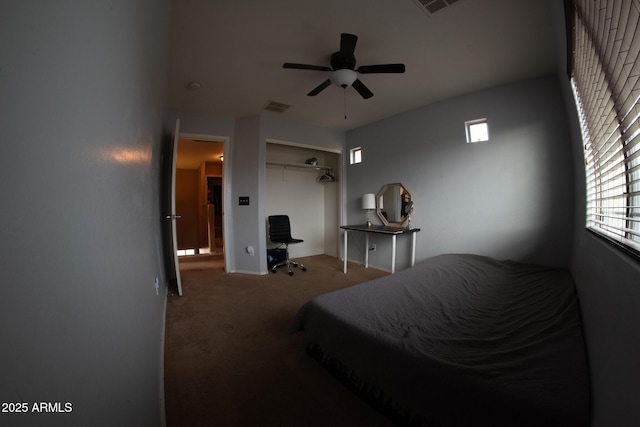 carpeted bedroom with visible vents, a closet, and ceiling fan