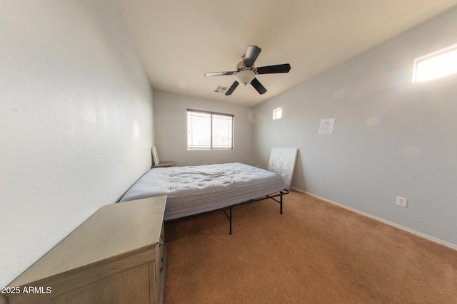 carpeted bedroom with baseboards, a ceiling fan, and visible vents