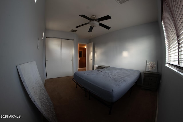 bedroom with visible vents, a closet, a ceiling fan, and carpet floors