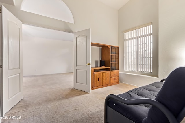 carpeted living room featuring high vaulted ceiling