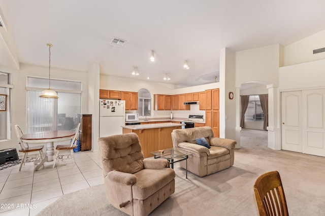 tiled living room featuring lofted ceiling and sink