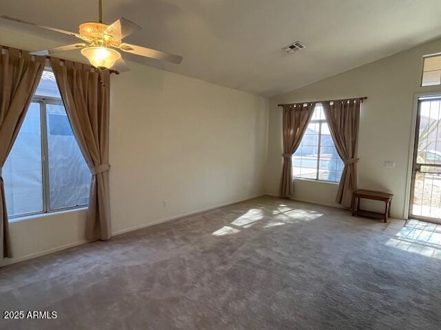 empty room featuring lofted ceiling, ceiling fan, and carpet flooring