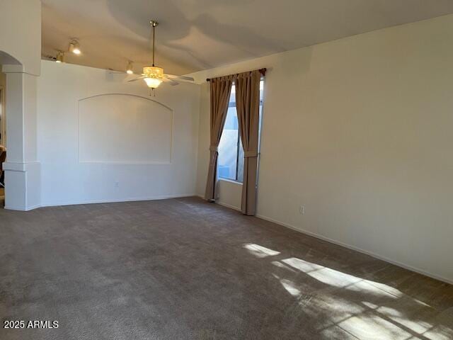 empty room featuring ceiling fan and dark colored carpet