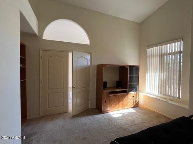 unfurnished bedroom featuring lofted ceiling and light colored carpet