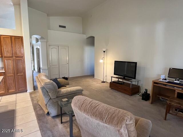 living room featuring light colored carpet and high vaulted ceiling