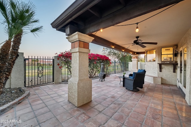 patio terrace at dusk featuring ceiling fan