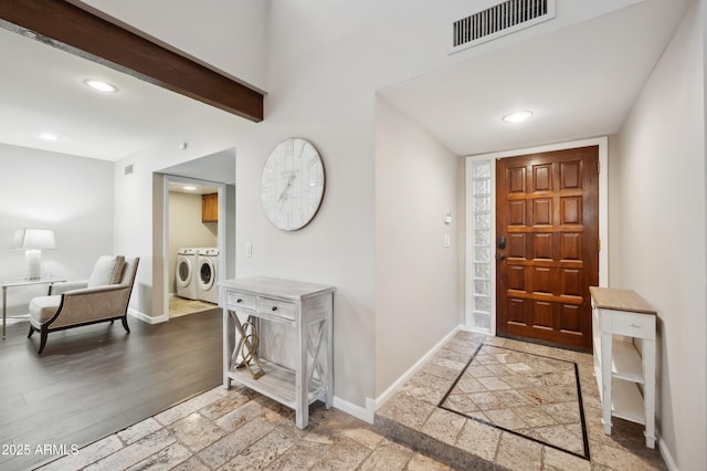 entryway featuring beamed ceiling, washer and clothes dryer, and light wood-type flooring