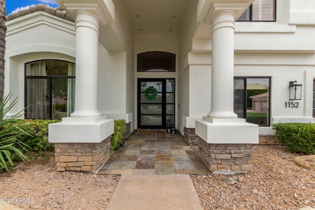 doorway to property featuring stucco siding and a tiled roof