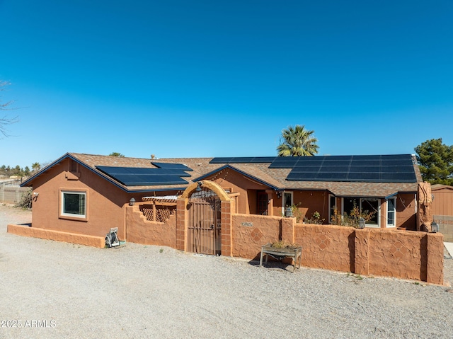 ranch-style home featuring solar panels