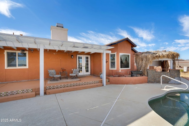 back of property featuring a bar, a pergola, a patio area, and french doors