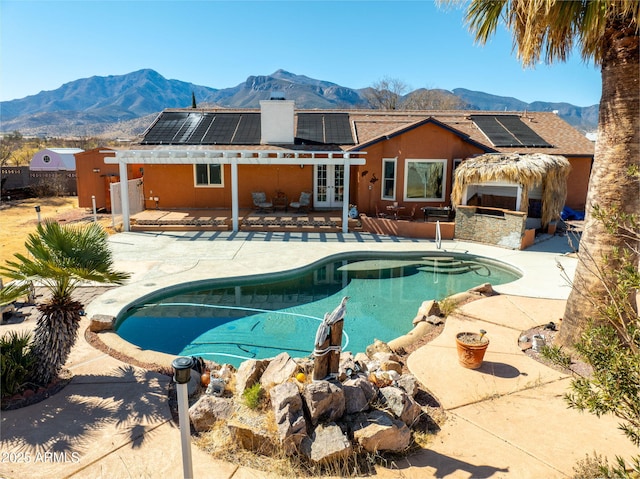 view of swimming pool featuring a mountain view, a patio area, and exterior kitchen