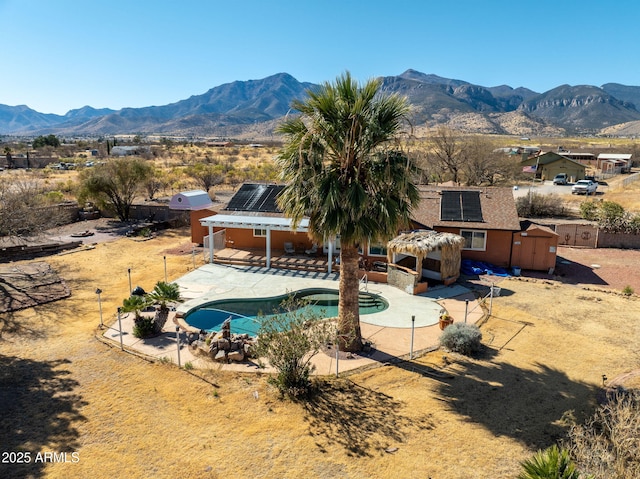 view of pool featuring an outbuilding, a mountain view, and a patio