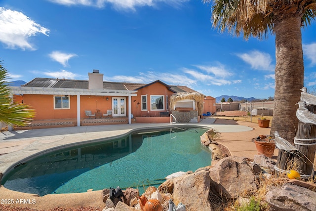 view of swimming pool with french doors and a patio