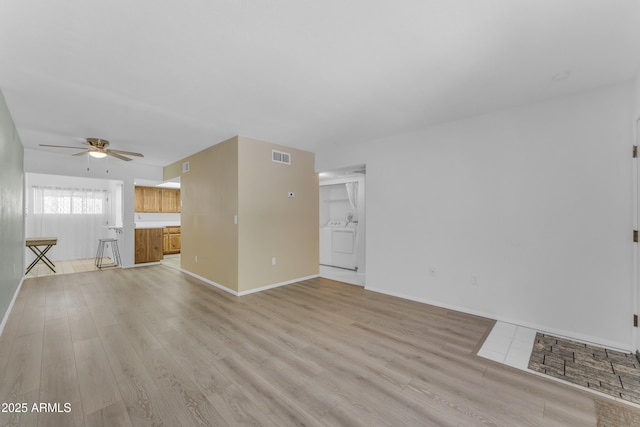 461 W Holmes Ave Unit 180, Mesa, AZ 85210 - unfurnished living room with a ceiling fan, light wood-type flooring, and independent washer and dryer