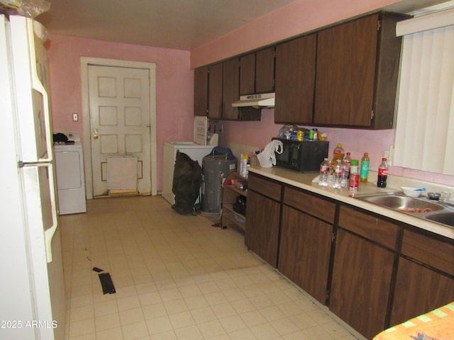 2045 S 6th Ave, Phoenix, AZ 85003 - kitchen with black microwave, washer / clothes dryer, under cabinet range hood, freestanding refrigerator, and light countertops