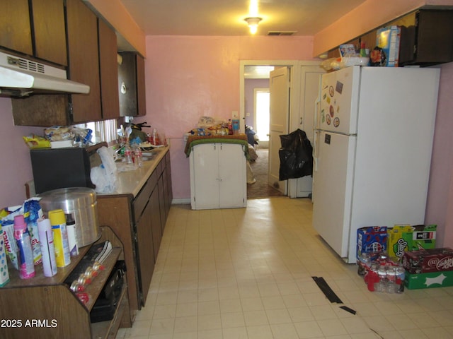 2045 S 6th Ave, Phoenix, AZ 85003 - kitchen featuring freestanding refrigerator, light countertops, and under cabinet range hood