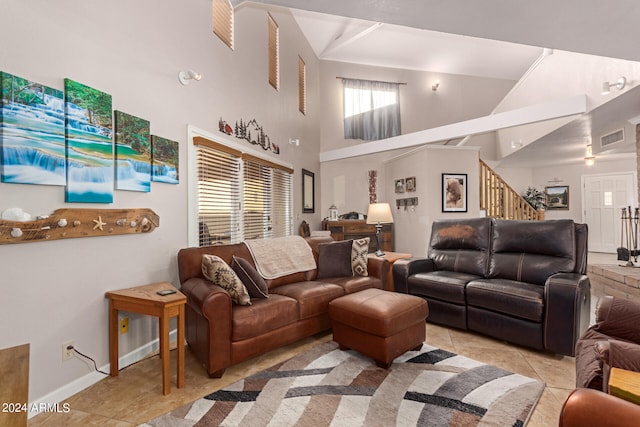 living room with light tile patterned flooring and high vaulted ceiling