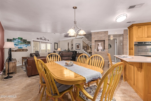 dining area with ornamental molding, lofted ceiling, a notable chandelier, and light tile patterned floors