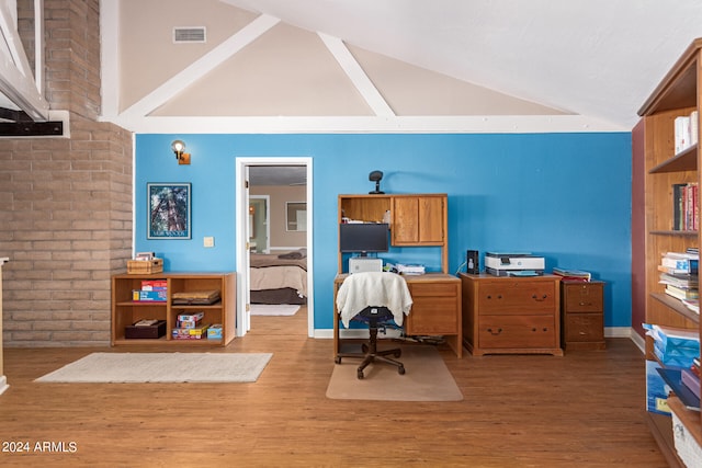 office with high vaulted ceiling and wood-type flooring