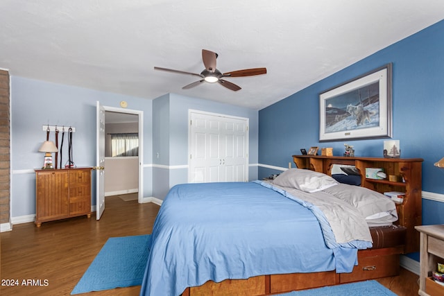 bedroom with a closet, dark hardwood / wood-style floors, and ceiling fan