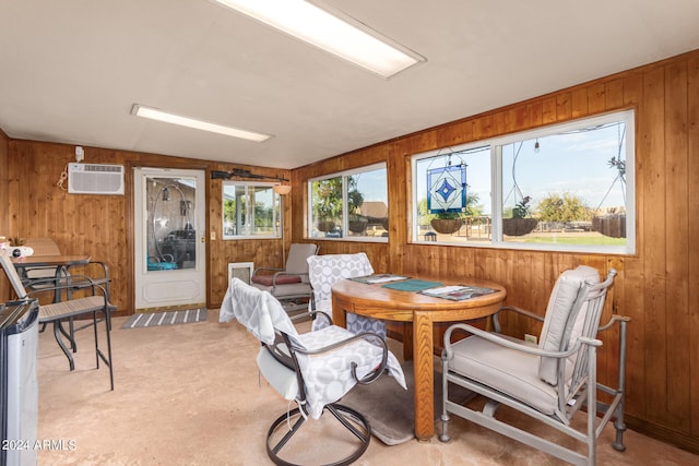 carpeted dining space featuring a wall mounted air conditioner, wood walls, and vaulted ceiling