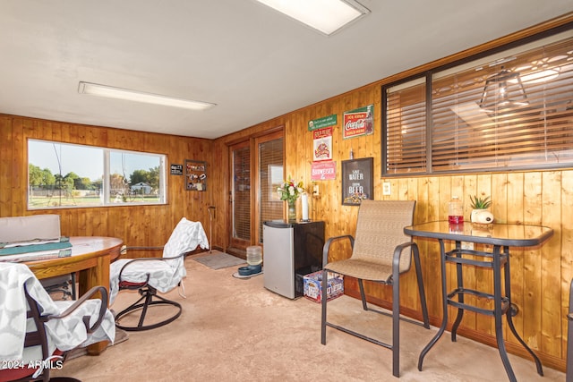 carpeted office featuring wooden walls