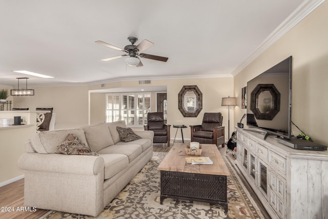 living room featuring ceiling fan, crown molding, and light hardwood / wood-style flooring