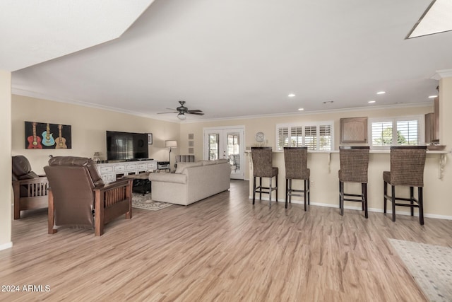 living room featuring ceiling fan, light hardwood / wood-style flooring, and ornamental molding