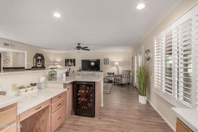 kitchen featuring wine cooler, light hardwood / wood-style flooring, ceiling fan, ornamental molding, and kitchen peninsula