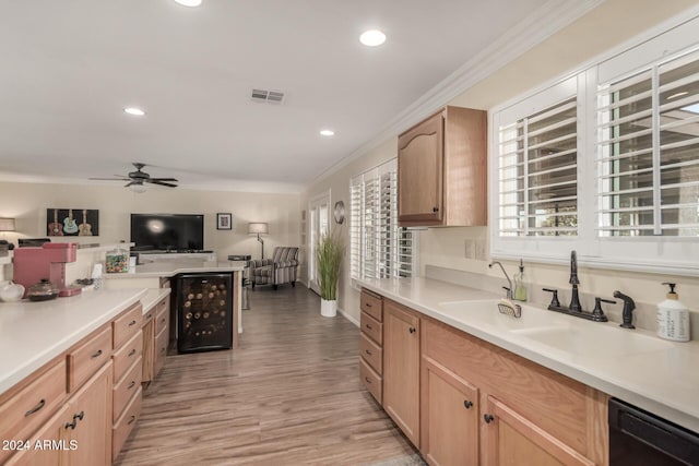 kitchen featuring ceiling fan, sink, black dishwasher, crown molding, and light wood-type flooring