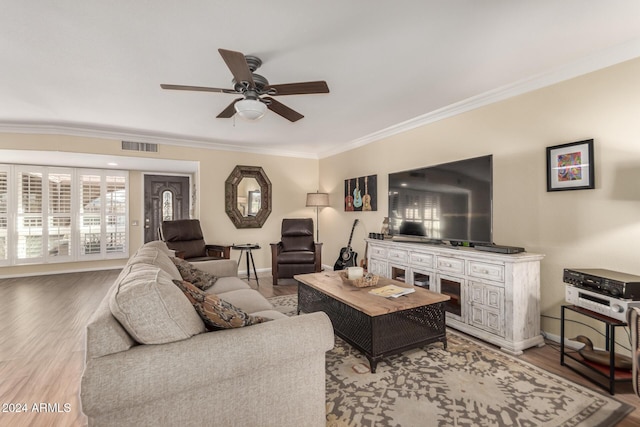 living room with light hardwood / wood-style flooring, ceiling fan, and crown molding