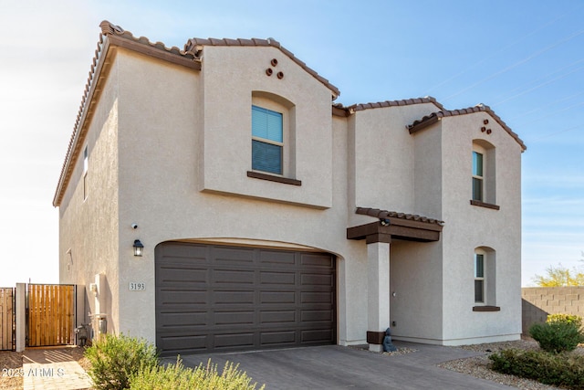 mediterranean / spanish-style home featuring a garage, a tile roof, and stucco siding