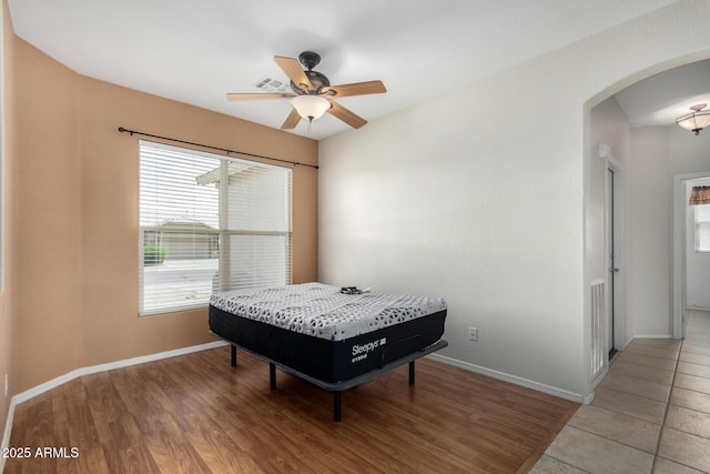 6372 S Callaway Dr, Chandler, AZ 85249 - bedroom featuring visible vents, baseboards, arched walkways, a ceiling fan, and wood finished floors