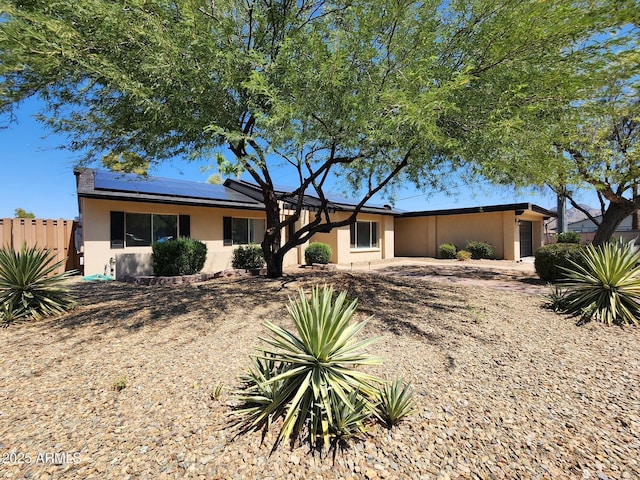 ranch-style home with solar panels