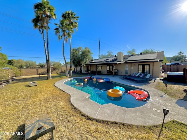 view of swimming pool featuring french doors, a patio, a hot tub, and a lawn