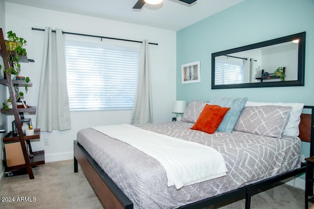 carpeted bedroom featuring multiple windows and ceiling fan