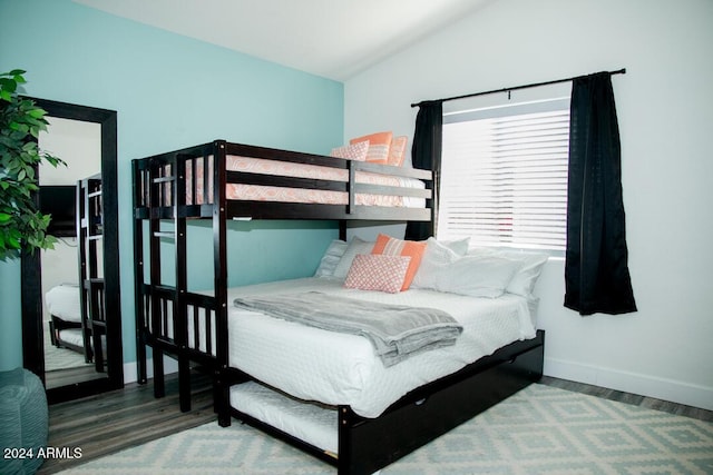 bedroom with hardwood / wood-style floors and vaulted ceiling