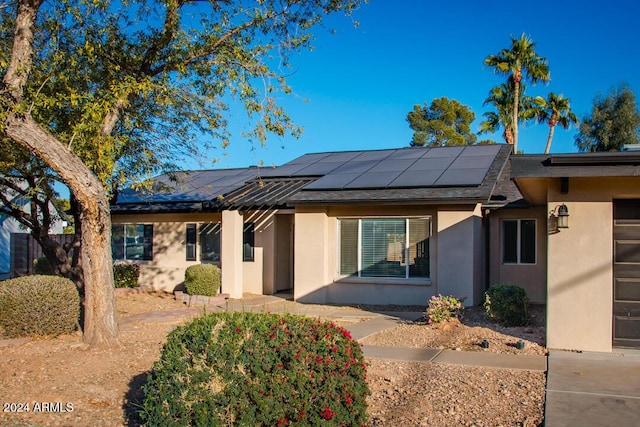 ranch-style house featuring solar panels