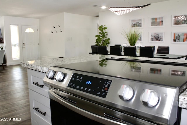 kitchen featuring white cabinetry, dark hardwood / wood-style flooring, and stainless steel electric range oven