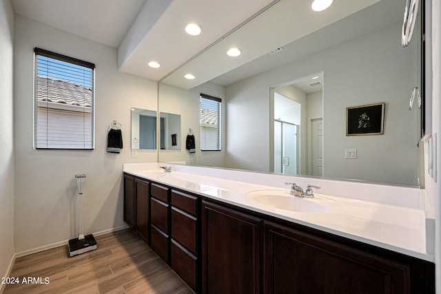 bathroom with dual vanity and hardwood / wood-style flooring