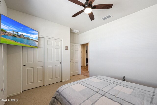 carpeted bedroom featuring a closet and ceiling fan