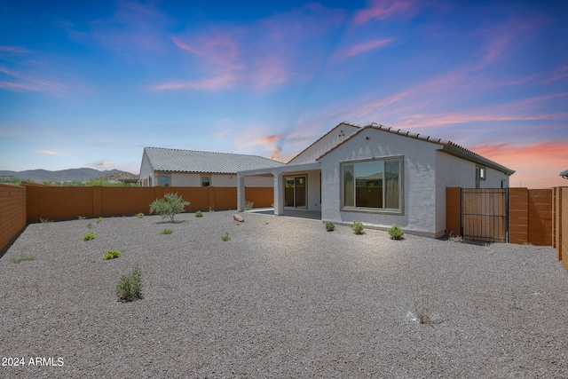 back house at dusk with a patio